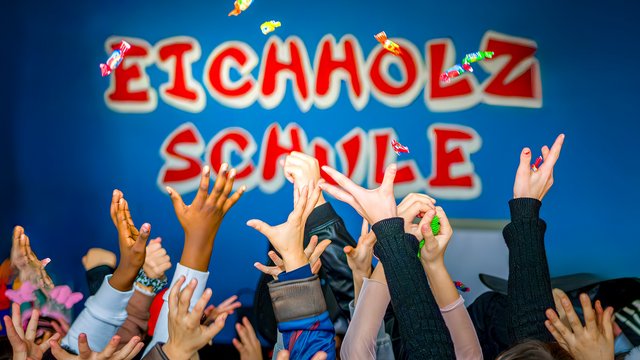 Schriftzug Eichholzschule mit Kinderhänden